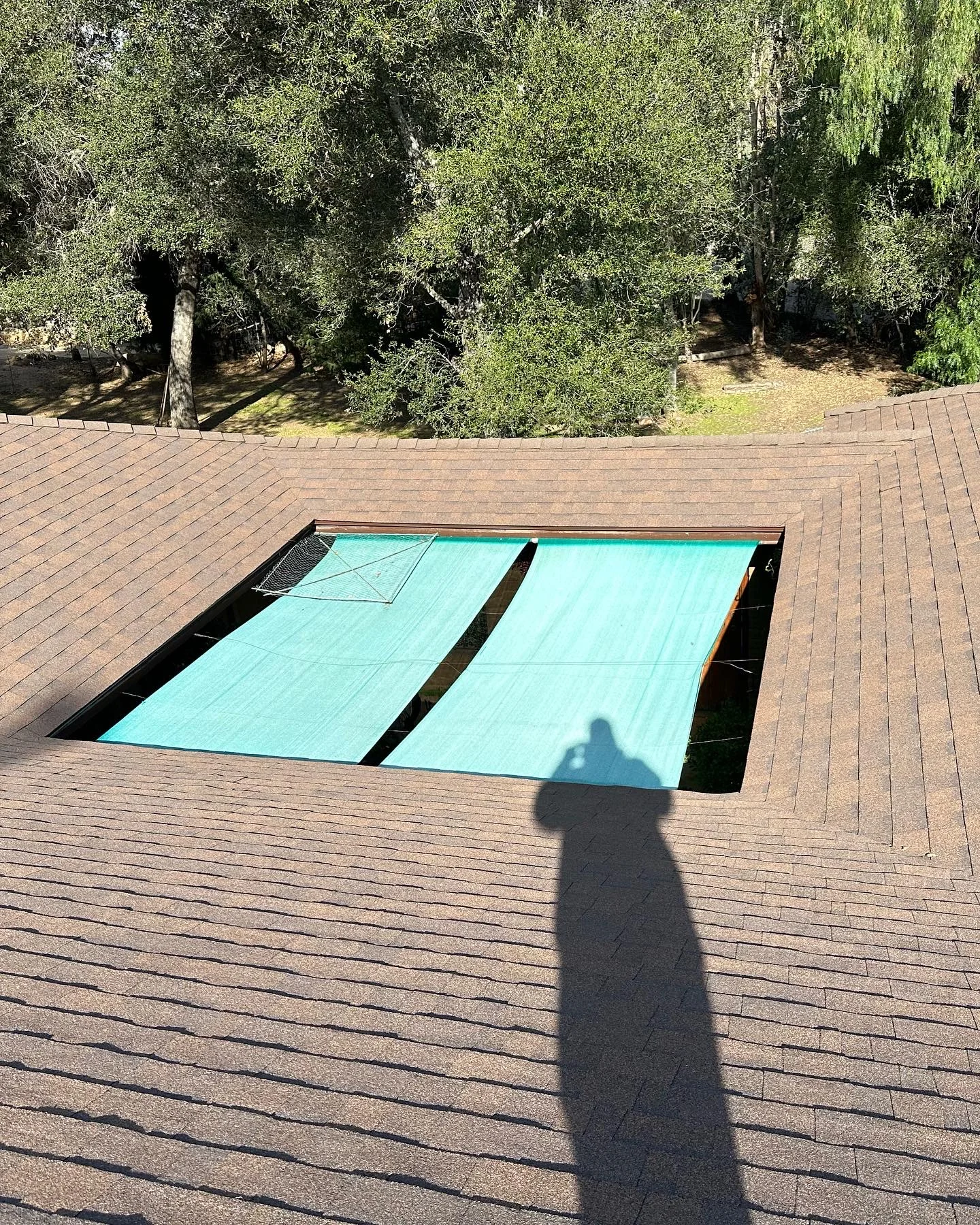 In-ground pool with turquoise safety cover surrounded by composite deck boards