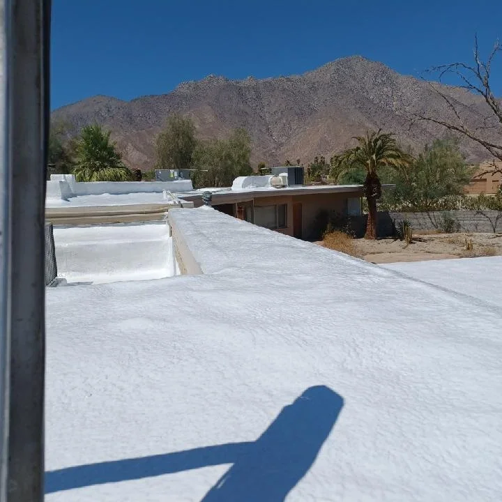 White flat roof membrane installation on commercial building with mountain backdrop
