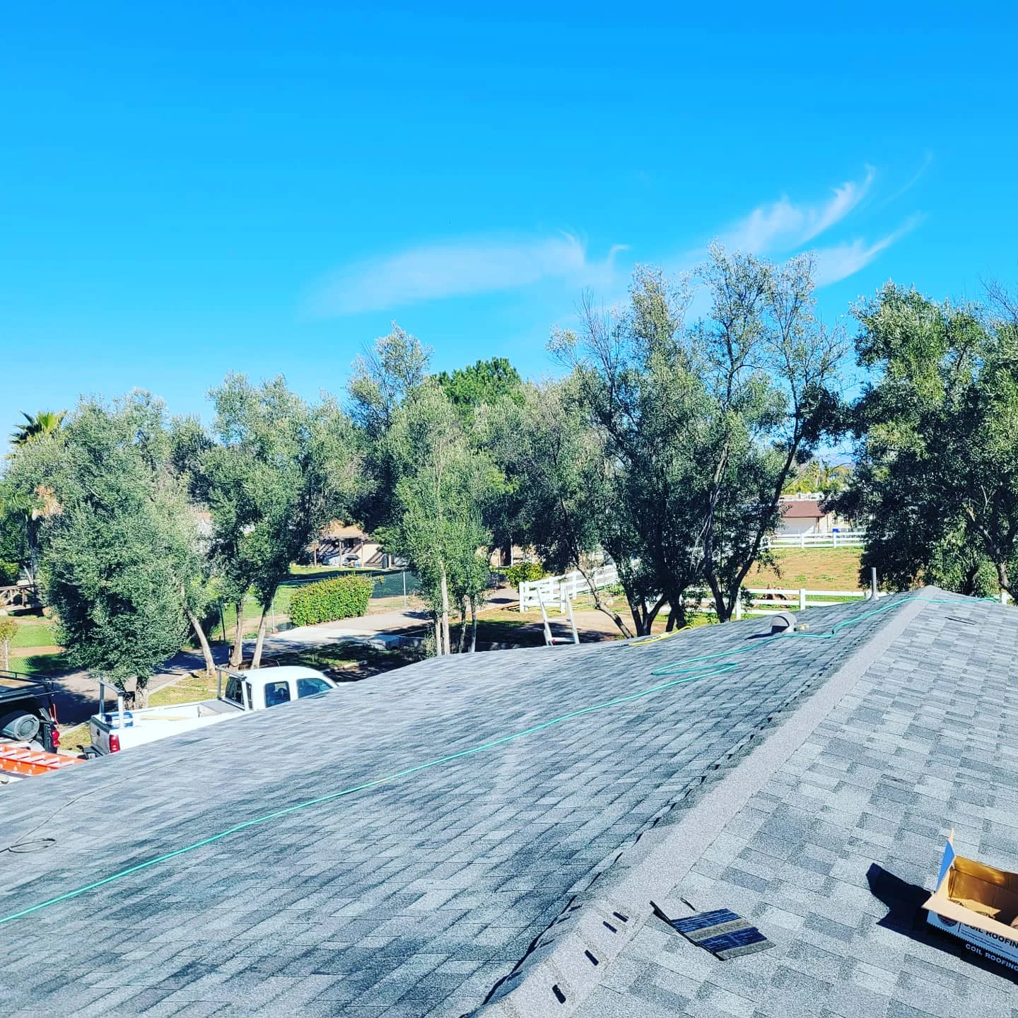 Roof installation in progress showing new asphalt shingles and underlayment on residential home
