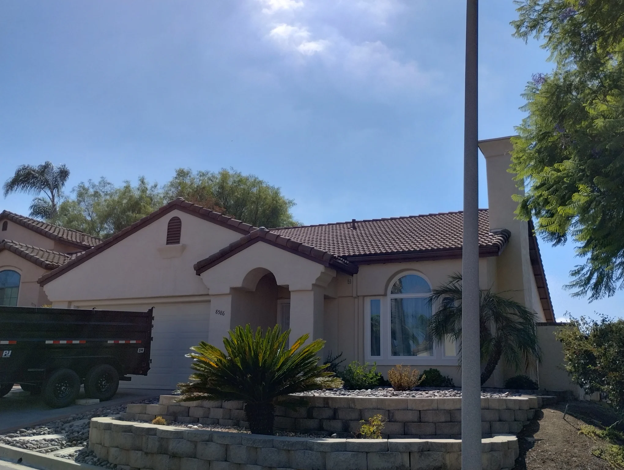 Spanish-style home with new dark clay barrel tile roof and brown trim accents